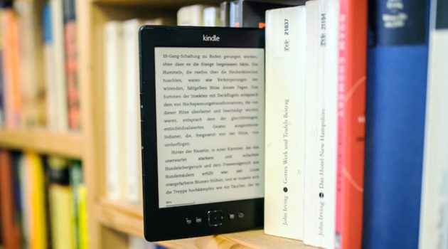 ILLUSTRATION - A kindle e-book reader between several novels in a bookshelf. The photo was taken on 05 January 2015 in Dresden (Saxony). Photo by: Thomas Eisenhuth/picture-alliance/dpa/AP Images